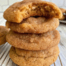 Golden brown chewy pumpkin snickerdoodle cookies with crackled cinnamon-sugar tops arranged on parchment paper