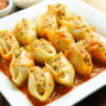 Baked pumpkin ricotta stuffed shells with melted cheese on top in a baking dish