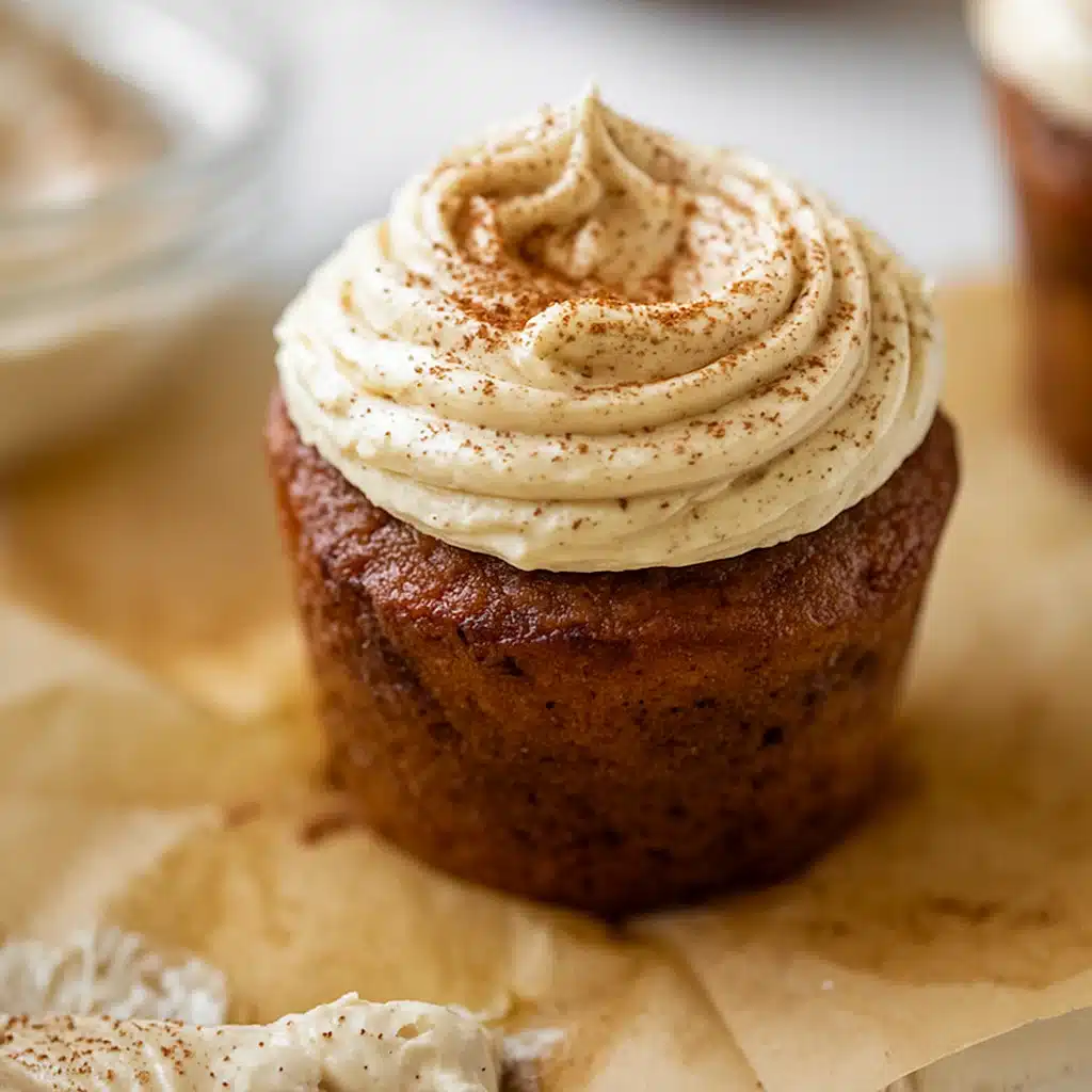 Pumpkin dream cupcakes with espresso cream cheese frosting arranged on a wooden board with fall decorations